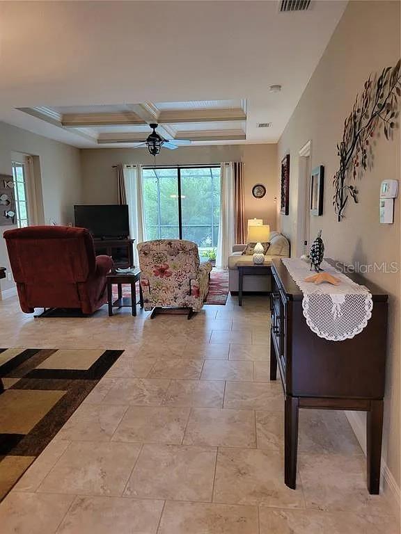 142 Yellow Pine Dr, Rotonda West, FL 33947 - living room featuring healthy amount of natural light, ceiling fan, coffered ceiling, and beam ceiling