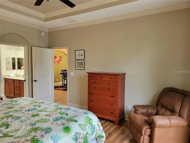 142 Yellow Pine Dr, Rotonda West, FL 33947 - bedroom with crown molding, light wood finished floors, baseboards, arched walkways, and a raised ceiling