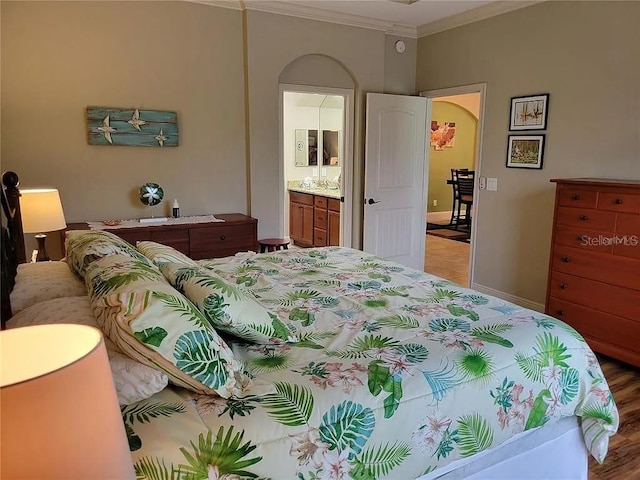 142 Yellow Pine Dr, Rotonda West, FL 33947 - bedroom featuring ornamental molding, arched walkways, ensuite bath, wood finished floors, and baseboards