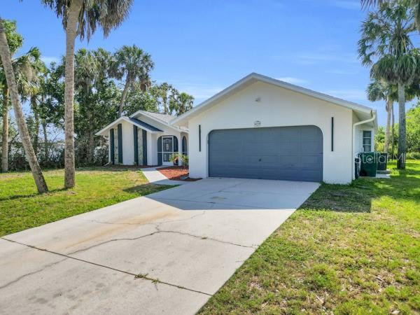 4210 Day St, Port Charlotte, FL 33948 - ranch-style house with a garage, stucco siding, and a front lawn