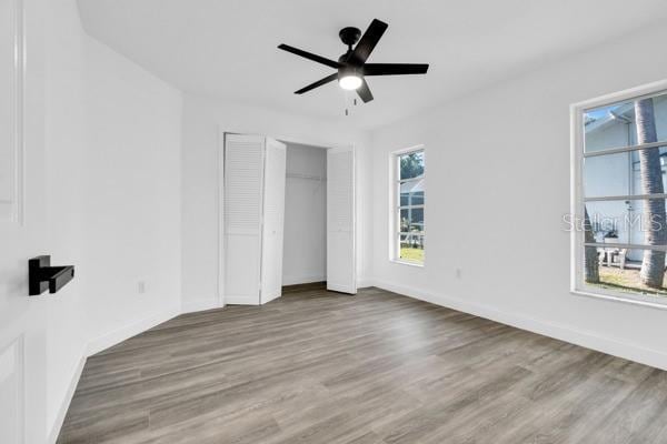 4210 Day St, Port Charlotte, FL 33948 - unfurnished bedroom with wood finished floors, baseboards, a closet, and a ceiling fan