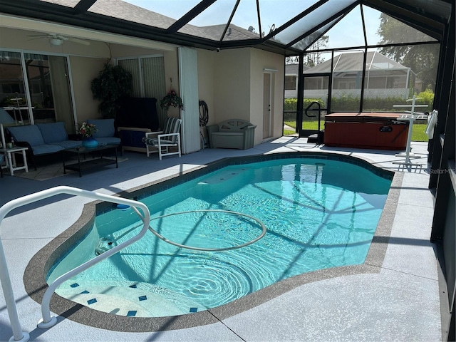swimming pool with a hot tub, a patio area, glass enclosure, and an outdoor hangout area