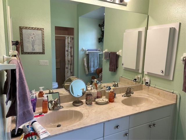 full bathroom featuring a textured wall, double vanity, curtained shower, and toilet