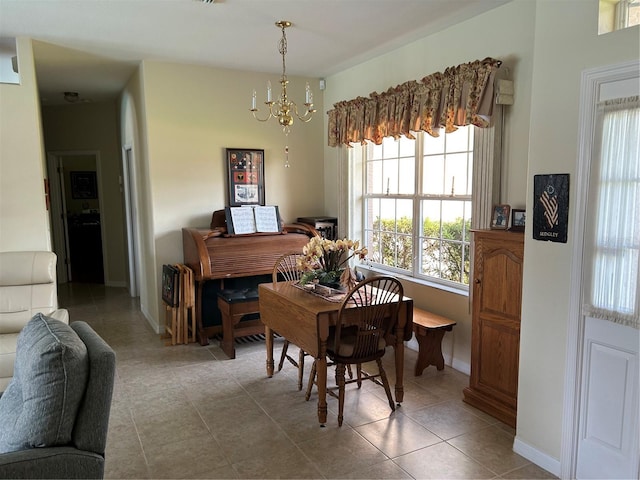 dining room featuring tile patterned flooring, a chandelier, and baseboards
