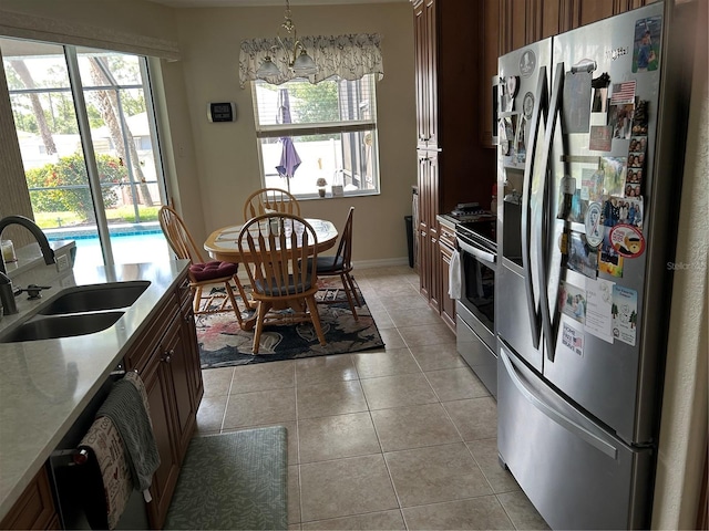 kitchen featuring stainless steel appliances, a sink, healthy amount of natural light, and light countertops