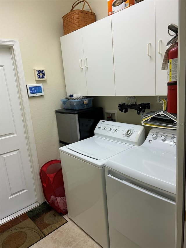 washroom featuring cabinet space and washing machine and clothes dryer