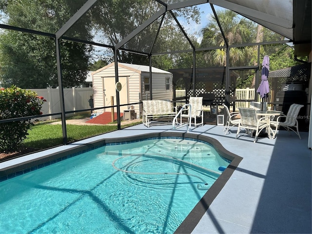 view of swimming pool with a storage unit, a patio area, an outbuilding, a fenced backyard, and a lanai