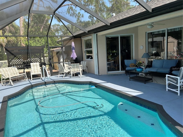 outdoor pool featuring a patio, an outdoor hangout area, ceiling fan, and glass enclosure