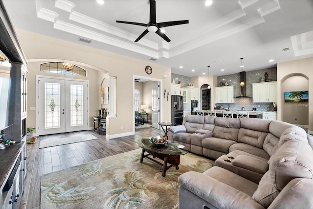 15044 San Domingo Blvd, Port Charlotte, FL 33981 - living area featuring a raised ceiling, arched walkways, french doors, crown molding, and a ceiling fan