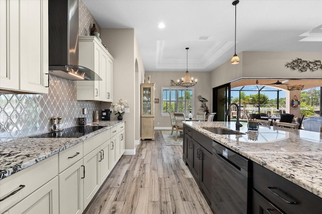 15044 San Domingo Blvd, Port Charlotte, FL 33981 - kitchen with dishwashing machine, wall chimney range hood, a sink, black electric cooktop, and a raised ceiling