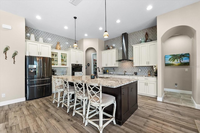 15044 San Domingo Blvd, Port Charlotte, FL 33981 - kitchen with black appliances, wall chimney range hood, arched walkways, a sink, and a kitchen island with sink