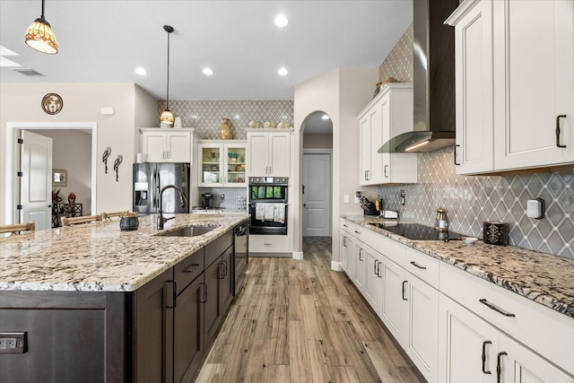 15044 San Domingo Blvd, Port Charlotte, FL 33981 - kitchen featuring wall chimney exhaust hood, black appliances, a sink, light wood finished floors, and white cabinets