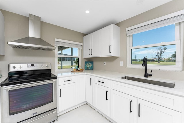11 Oakland Hills Rd, Rotonda West, FL 33947 - kitchen with stainless steel electric stove, wall chimney range hood, a sink, white cabinetry, and recessed lighting