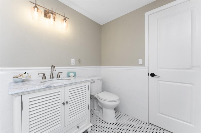 11 Oakland Hills Rd, Rotonda West, FL 33947 - bathroom with wainscoting, toilet, vanity, and tile walls
