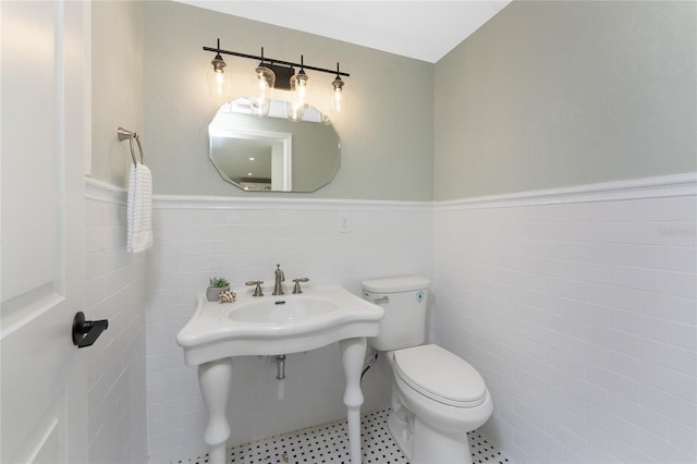 11 Oakland Hills Rd, Rotonda West, FL 33947 - half bathroom with toilet, wainscoting, tile walls, and tile patterned flooring