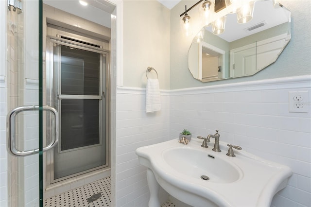 11 Oakland Hills Rd, Rotonda West, FL 33947 - bathroom featuring tile walls, a shower stall, wainscoting, and a sink
