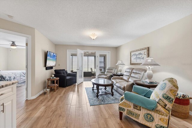 507 Pine Hollow Cir Unit 507, Englewood, FL 34223 - living area with light wood-style floors, a ceiling fan, a textured ceiling, and baseboards