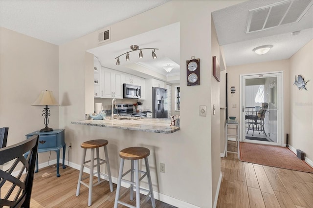 507 Pine Hollow Cir Unit 507, Englewood, FL 34223 - kitchen with appliances with stainless steel finishes, light wood-style floors, baseboards, and a raised ceiling
