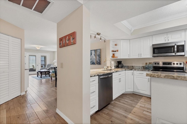 507 Pine Hollow Cir Unit 507, Englewood, FL 34223 - kitchen featuring stainless steel appliances, light wood-type flooring, a sink, white cabinetry, and crown molding