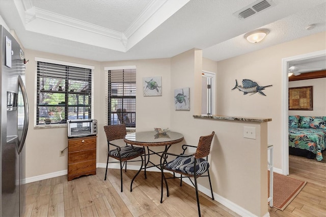 507 Pine Hollow Cir Unit 507, Englewood, FL 34223 - dining area with a tray ceiling, ornamental molding, wood finished floors, baseboards, and a textured ceiling