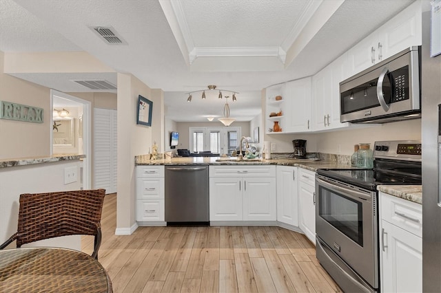 507 Pine Hollow Cir Unit 507, Englewood, FL 34223 - kitchen featuring stainless steel appliances, a sink, crown molding, light wood-style floors, and white cabinetry