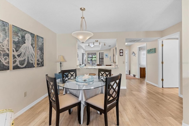 507 Pine Hollow Cir Unit 507, Englewood, FL 34223 - dining room with light wood finished floors, baseboards, and a textured ceiling