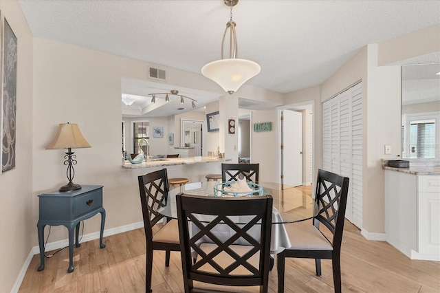 507 Pine Hollow Cir Unit 507, Englewood, FL 34223 - dining area featuring light wood-style flooring, baseboards, and a textured ceiling