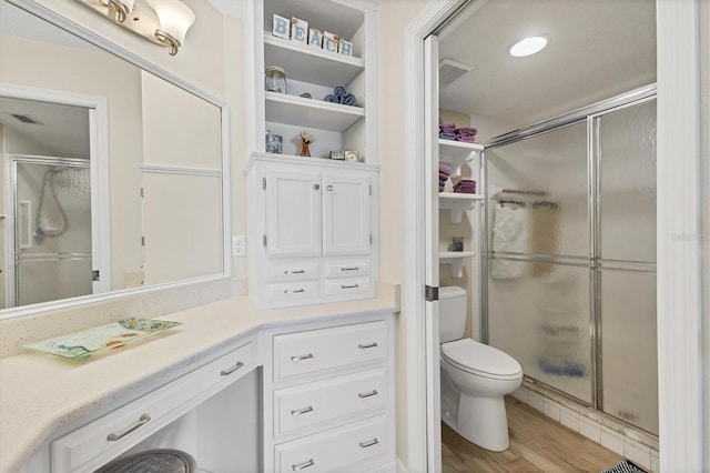 507 Pine Hollow Cir Unit 507, Englewood, FL 34223 - bathroom featuring a stall shower, toilet, wood finished floors, and vanity