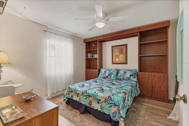 507 Pine Hollow Cir Unit 507, Englewood, FL 34223 - bedroom with light wood finished floors, a textured ceiling, a ceiling fan, and baseboards