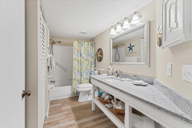 507 Pine Hollow Cir Unit 507, Englewood, FL 34223 - full bathroom featuring toilet, wood finished floors, shower / bath combo, a textured ceiling, and vanity