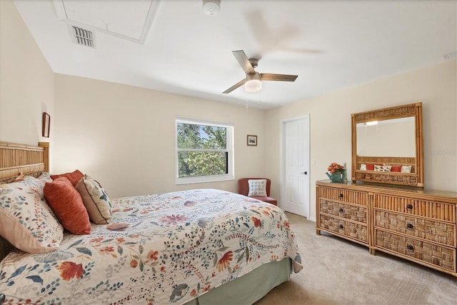 bedroom with attic access, carpet flooring, and ceiling fan