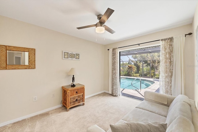 living area with carpet floors, a ceiling fan, and baseboards
