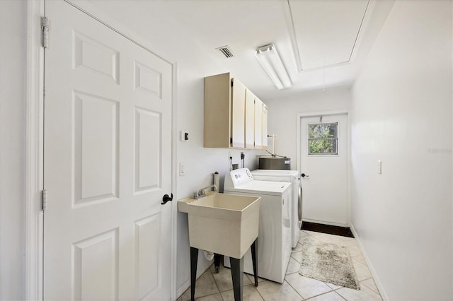 laundry area featuring cabinet space, attic access, washing machine and clothes dryer, baseboards, and light tile patterned floors