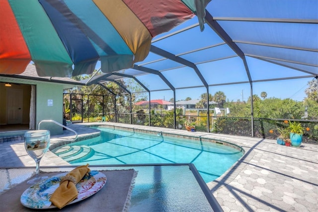 swimming pool featuring a patio and glass enclosure