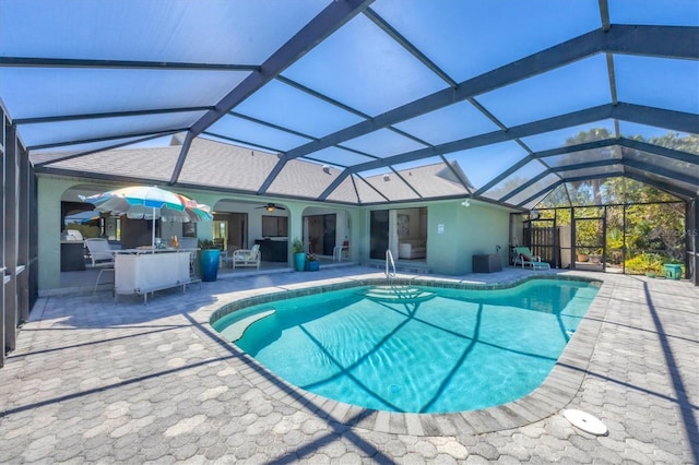 swimming pool featuring a patio area, ceiling fan, and a lanai