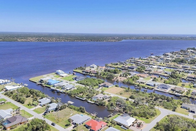 aerial view of property's location featuring a large body of water and nearby suburban area