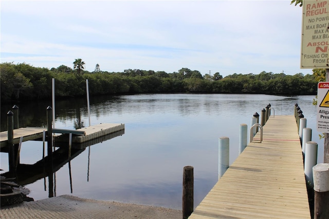 dock area featuring a water view and a wooded view