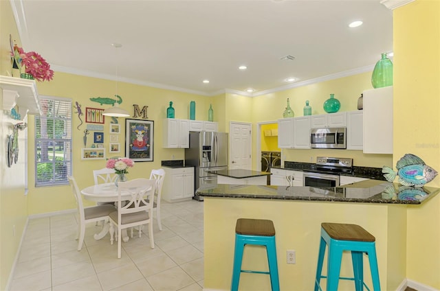 2692 Wax Myrtle Ct, Port Charlotte, FL 33953 - kitchen featuring appliances with stainless steel finishes, a peninsula, light tile patterned floors, white cabinets, and dark stone countertops