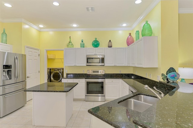 2692 Wax Myrtle Ct, Port Charlotte, FL 33953 - kitchen featuring appliances with stainless steel finishes, washer / clothes dryer, a sink, crown molding, and white cabinets