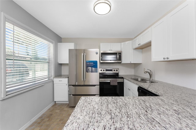 5041 N Beach Road 2A And 2B, Englewood, FL 34223 - kitchen with appliances with stainless steel finishes, baseboards, a sink, light stone counters, and white cabinetry