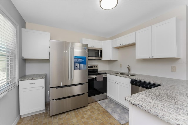 5041 N Beach Road 2A And 2B, Englewood, FL 34223 - kitchen with appliances with stainless steel finishes, a sink, white cabinets, and light stone counters