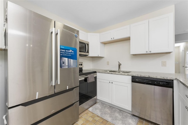 5041 N Beach Road 2A And 2B, Englewood, FL 34223 - kitchen with appliances with stainless steel finishes, a sink, white cabinets, and light stone counters