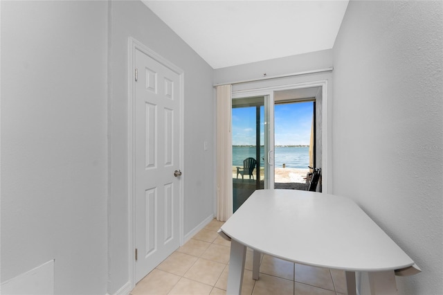 5041 N Beach Road 2A And 2B, Englewood, FL 34223 - dining space featuring a water view, light tile patterned flooring, and baseboards