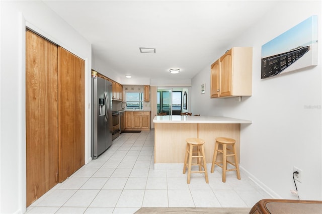 5041 N Beach Road 2A And 2B, Englewood, FL 34223 - kitchen featuring stainless steel refrigerator with ice dispenser, a peninsula, a breakfast bar, light countertops, and light tile patterned flooring