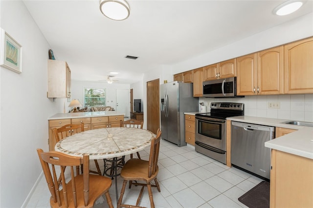 5041 N Beach Road 2A And 2B, Englewood, FL 34223 - kitchen featuring appliances with stainless steel finishes, light countertops, decorative backsplash, ceiling fan, and light tile patterned floors