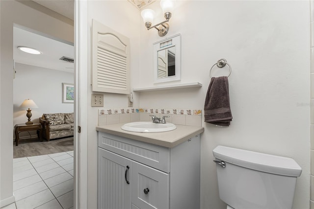 5041 N Beach Road 2A And 2B, Englewood, FL 34223 - bathroom featuring vanity, toilet, decorative backsplash, and tile patterned floors