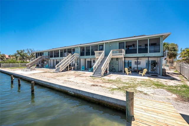5041 N Beach Road 2A And 2B, Englewood, FL 34223 - rear view of house featuring a sunroom, stairway, a water view, and a fenced backyard