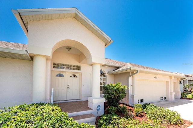 1157 Rotonda Cir, Rotonda West, FL 33947 - entrance to property with stucco siding, a garage, and driveway