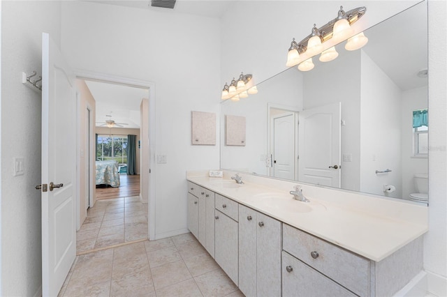 1157 Rotonda Cir, Rotonda West, FL 33947 - ensuite bathroom featuring double vanity, ceiling fan, toilet, baseboards, and tile patterned flooring