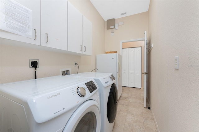 1157 Rotonda Cir, Rotonda West, FL 33947 - washroom featuring cabinet space, washing machine and clothes dryer, baseboards, light tile patterned floors, and a textured wall